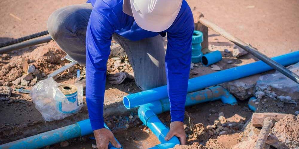 Plumber working on a busted pipe line
